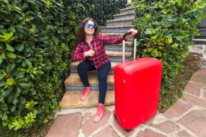 vacances-voyages-concept-personnes-jeune-femme-lunettes-soleil-assis-escaliers-valises-souriant
